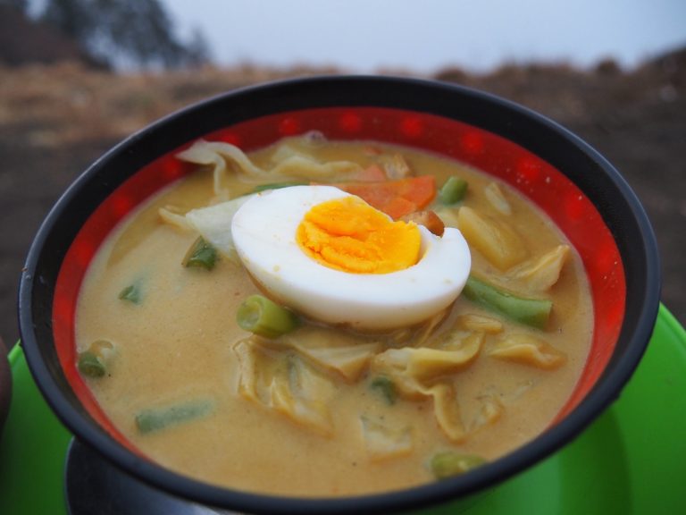 Bowl of vegetable soup with a boiled egg, cooked on the trek